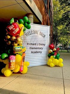 some balloons are sitting in front of a welcome sign