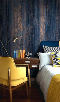 a bedroom with blue and yellow wallpaper, a chair, desk and bed in it