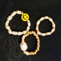 Freshwater pearl stretch bead rings. Three different styles. Freshwater pearls and smiley face. Freshwater pearls and gold glass seed beads. Large  Freshwater pearl and gold glass seed beads  Stretchy.  Sizes  5/6/7  cms. S/M/L Made using strong 5mm crystal stretch elastic. Super cute and ideal to wear on its own or as stacking rings. Adjustable Smiley Face Round Bead Jewelry, Trendy Pearl White Round Bead Jewelry, Trendy Pearl White Beaded Jewelry, Trendy Round Pearl Bead Jewelry, Trendy Pearl Jewelry With Round Beads, Adjustable Beaded Pearl Ring, Trendy Adjustable Pearl Drop Jewelry, Adjustable Trendy Pearl White Jewelry, Trendy Inelastic Round Beaded Jewelry