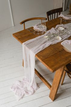 a wooden table topped with plates and glasses next to a white rug on the floor