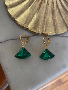 Vintage emerald green glass stone set in a raw brass setting measuring 1.8 cm x 1.3 cm. Hung on gold-plated huggie hoop earrings measuring 1.2 cm x 1.4 cm. Comes in a black velvet pouch. If these are a gift and you would like a box free of charge please mark the order as gift or leave a message at check out. Green Huggie Earrings With Matching Set, Green Tarnish-resistant Huggie Jewelry, Green Small Hoop Earrings Tarnish Resistant, Green Nickel-free Huggie Earrings, Small Hoop Green Earrings Tarnish Resistant, Small Hoop Green Tarnish-resistant Earrings, Green Tarnish Resistant Small Hoop Earrings, Green Tarnish-resistant Hoop Jewelry, Green Tarnish Resistant Hoop Earrings For Gift