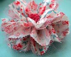 an origami flower with red and white flowers on it's petals, sitting on a blue surface