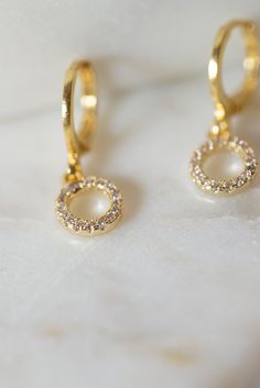 Our Myla Dainty O-Ring Huggie Earrings are the perfect minimalist earrings! Made with a crystal beaded gold filled O-Ring attached to a gold filled huggie hoop. These simple earrings are a beautiful staple piece! Everyday Gold Crystal Earrings, Gold Huggie Earrings With Halo For Gift, Dainty Hoop Earrings With Sparkling Stones For Gift, Gold Cubic Zirconia Hoop Earrings With Halo, Gold Earrings With Sparkling Stones For Everyday, Gold Halo Earrings Perfect As A Gift, Minimalist Single Gold Crystal Earring, Gold Halo Earrings For Gift, Gold Halo Earrings Perfect For Gifts