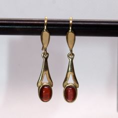 Garnet 9ct solid gold drop earrings 9ct hallmarked solid yellow gold drop earrings featuring oval Garnets, individual earring weight including gemstone 1g.     * Oval Garnet cabochons 6 x 4mm     * Drop Height: 18mm     * Drop Width: 6mm at widest point The traditional birthstone for the month of January and gemstone for the Astrology sign Aquarius 20 January-18 February. Highly prized and used in Anglo Saxon and Celtic tribal jewellery, garnets were believed to have the power to protect the wea Modern Oval Cabochon Earrings, Formal Drop Cabochon Earrings, Classic Gold Cabochon Earrings, Formal Dangle Earrings With Cabochon, Modern Cabochon Earrings For Formal Occasions, Classic Oval Pierced Earrings, Yellow Gold Oval Cabochon Earrings For Gift, Yellow Gold Oval Cabochon Earrings As Gift, Oval Cabochon 14k Gold Earrings