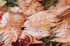 raw fish with lemons, oranges and herbs on a yellow plate for garnish