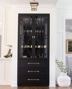 a black china cabinet with wine glasses on it