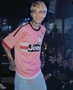 a man with tattoos standing in front of a crowd