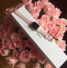 an apple watch is sitting in a box with pink roses around it and its packaging