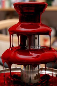 red liquid flowing down the side of a water fountain that is dripping on it's sides