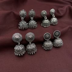 Introducing the exquisite 4-piece Jhumka Combo by Quirky Fashions, a must-have addition to your jewelry collection. Crafted from high-quality brass and adorned with a stunning German silver finish, these jhumkas combine traditional charm with modern elegance. Each pair features a convenient push-back closure, ensuring a secure and comfortable fit for all-day wear. Perfect for daily office wear, these jhumkas are designed to add a touch of sophistication to your professional attire. Whether you'r Heavy Drop Earrings Jhumkas, Diwali Drop Earrings Danglers, Heavy Drop Jhumkas, Gift Danglers For Navratri, Bollywood Style Intricate Design Jhumkas, Oxidized Finish Bollywood Earrings, Navratri Drop Earrings Jhumkas, Bollywood Style Oxidized Finish Earrings, Navratri Drop Danglers