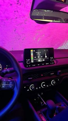 the interior of a car with purple lighting