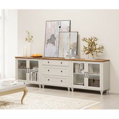 a white entertainment center with glass doors and drawers