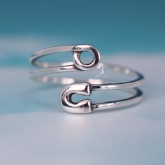 Experience the unique and stylish design of this safety pin open band ring, crafted from high-quality 925 sterling silver and finished with a platinum plating process for a luxurious shine. The addition of oxidation accents adds a pop of color and contrast. Plus, the open band design allows for easy adjustment to fit most finger sizes. Materials: 925 sterling silverFinish: platinum plateAdjustable from size US 5 - 8 Jewelry Care: See more information about how to care for your jewelry here. Ship Trendy Sterling Silver Open Band Midi Rings, Trendy Adjustable Sterling Silver Midi Rings, Trendy Nickel-free Sterling Silver Rings, Trendy Adjustable Sterling Silver Rings, Trendy Sterling Silver Jewelry With Open Band, Trendy Sterling Silver Open Band Jewelry, Trendy Sterling Silver Open Ring Jewelry, Trendy Sterling Silver Open Ring, Trendy Sterling Silver Toe Ring