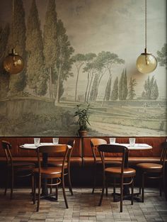 two tables and chairs in front of a wall with a painting on it's side