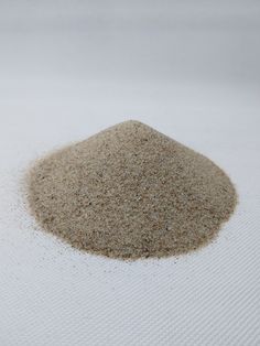 a pile of sand sitting on top of a white surface