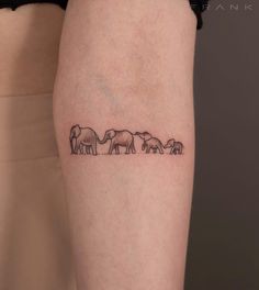 an elephant family tattoo on the right thigh, with three elephants in line behind it