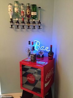 an illuminated bar cart in the corner of a room with bottles and glasses on it