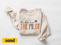 Dibs On The Pilot Sweatshirt, Pilot Wife Sweater Gift, Pilot Girlfriend, Pilot Gifts, Airplane Hoodie, Aviation Shirt, Pilot Wife Gifts, Gift For Women Welcome to my store! I will help you to have a good shopping experience as much as I can. If you have any request (design customization, more size and color options) please feel free to message me. I will reply as soon as possible. I have listed some information to help you below:  HOW TO ORDER  * Please, Check and Review all Photos. * Select Your Sweatshirt Color from drop down menus. * Choose Your Quantity as much as you want. * Click ADD TO CART. And, you can go back to add more product color for your family members and text colors or You can complete the checkout process.  CARE INSTRUCTIONS  For best results, wash inside out and lay fla Pilot Girlfriend, Wife Sweater, Pilot Wife, Wife Gifts, Pilot Gifts, The Pilot, Sweater Gift, Text Color, Gifts For Wife