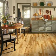 a kitchen filled with lots of furniture and wooden floors