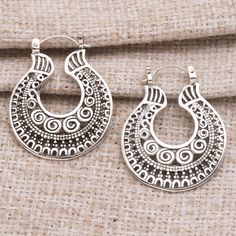 Bali's Dewi Putera presents these fascinating hoop earrings with saddleback clasps. Crafted from sterling silver using a combination of handwork and casting and oxidized for contrast the earrings feature traditional Balinese design details such as swirls and jawan or silver granules. Ornate Silver Hoop Earrings With Intricate Design, Silver Bohemian Hoop Earrings With Oxidized Finish, Ornate Silver Filigree Hoop Earrings, Sterling Silver Filigree Hoop Earrings, Balinese Design, Balinese Silver Jewelry, Earrings Making, Making Waves, Sterling Silver Hoop Earrings