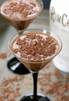 two martini glasses filled with chocolate and topped with powdered sugar