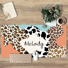 a mouse pad with the word melody written on it next to a keyboard and plant