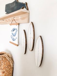 three surfboards are hanging on the wall next to a basket and wicker basket