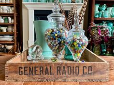 a wooden box filled with candy and candies on top of a table next to other items