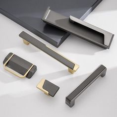 an assortment of metal handles and pulls on a white surface with black background, including one for the door