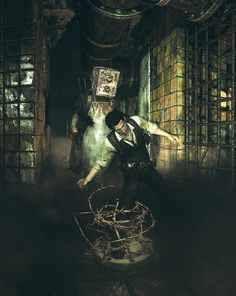 a man standing in front of a caged area with barbed wire on the floor