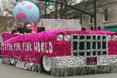 a parade float is decorated with pink and silver beads, fringes, and decorations