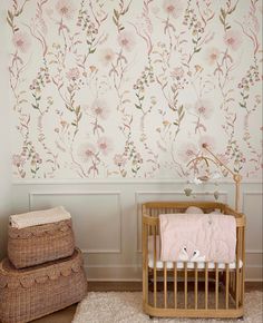 a baby crib next to a wall with flowers on it