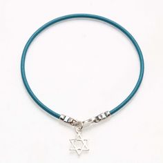 This lovely bracelet is made of turquoise leather with a sterling silver lobster clasp. Hanging from the red bracelet is a 925 Sterling Silver Star of David pendant. The pendant is diamond cut and very sparkly. The bracelet looks great on its own or stacked with others! Bracelet length: 7" Star measures 5/8" long by 3/8" wide Also available in red leather! Adjustable Turquoise Jewelry With Star Charm, Red Leather Bracelet, Red Bracelet, Jewish Star, Hamsa Charm, Hamsa Pendant, Star Of David Pendant, Turquoise Leather, Red Bracelets