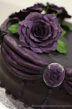 there is a cake with purple frosting and flowers on it