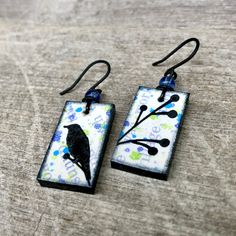 the earrings are decorated with black and white designs on them, while hanging from hooks