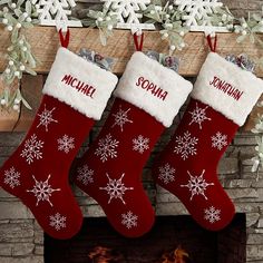 three christmas stockings hanging from a mantel with snowflakes on it and the words michael written in red