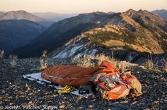 an orange sleeping bag sitting on top of a mountain