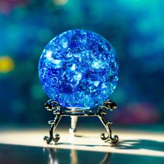 a blue glass ball sitting on top of a metal stand