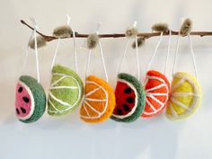 four felt fruit ornaments hanging on a branch