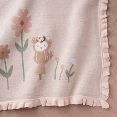 a pink blanket with an owl and flowers on it