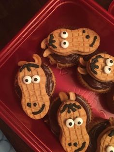 some cupcakes with googly eyes and mustaches on them in a red tray