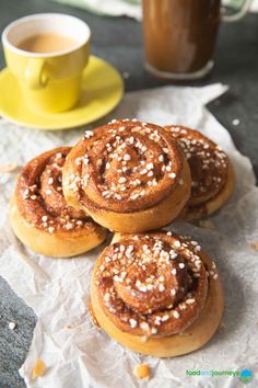 cinnamon buns with sugar sprinkled on top and cup of coffee in the background