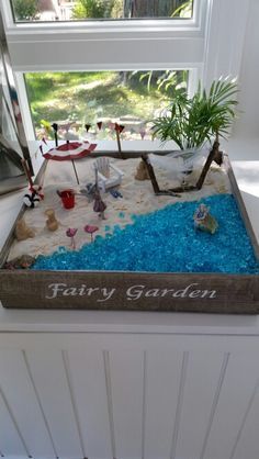 a fake garden is displayed in front of a window with the words fairy garden written on it