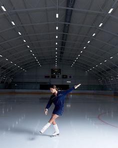 a woman skating on an ice rink wearing knee high socks and holding her arms out