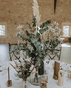 there is a vase with some flowers in it on the table at this wedding reception