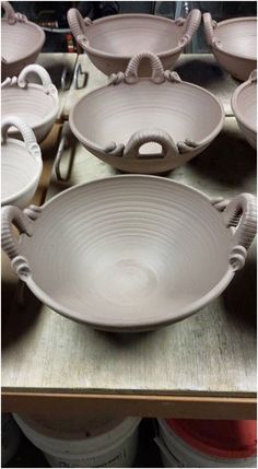 several bowls are sitting on a table with other items in the background and one is empty