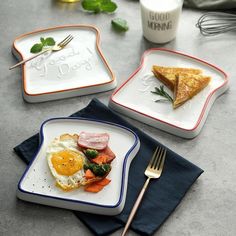 three plates with food on them sitting on a table next to a fork and knife