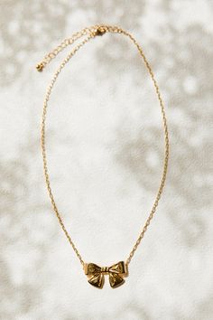 Add some whimsy to your jewelry collection with our Gold Bow Necklace. This playful piece features a delicate gold chain and a charming bow charm. With its convenient lobster closure, you'll never have to worry about losing this stylish accessory. Perfect for any occasion! Delicate Gold Chain, Made By Mary, Bow Necklace, Bow Jewelry, Stylish Accessories, Gold Chain, Gold Chains, Ivy, Jewelry Collection