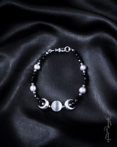 In honour of Artemis, Goddess of the wilds and Goddess of the moon. She who wears the crescent moon crown. An enchanting beaded bracelet featuring a Selenite sphere framed by crescent moons, and strung between black Onyx and silver freshwater pearls. This bracelet depicts the Triple Goddess symbol, the Selenite bead in the centre symbolising the full moon with a waxing and waning crescent on either side.  The crescent moon beads are produced in sterling silver and are uniquely textured by hand g Mystical Adjustable Moon Phase Jewelry, Adjustable Mystical Moon Phase Jewelry, Silver Bracelet With Moon Charm And Round Beads, Silver Bracelets With Moon Charm And Round Beads, Celestial Crescent Bracelets With Moon Charm, Celestial Round Beads Jewelry For Festival, Celestial Style Festival Jewelry With Round Beads, Bohemian Moon Phase Round Beaded Jewelry, Celestial Moon Phase Bracelet