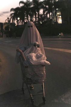 a ghost pushing a shopping cart down the street